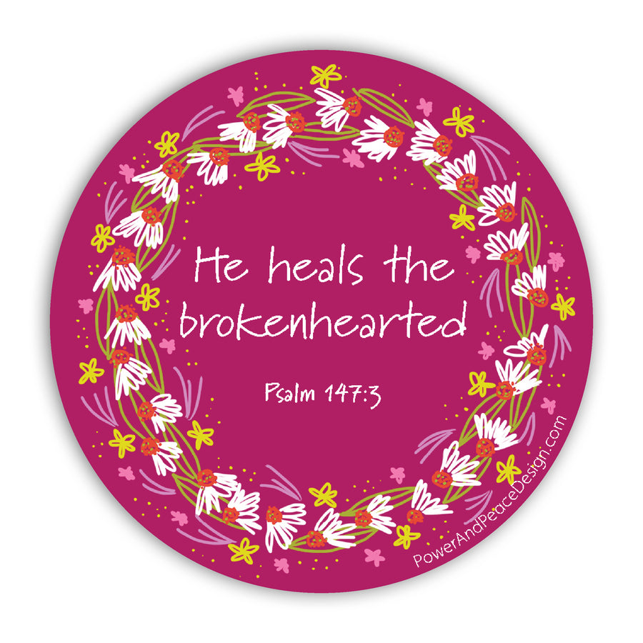 Berry pink Christian sticker with Psalm 147:3 He heals the brokenhearted. Words are surrounded by a wreath of daisies.