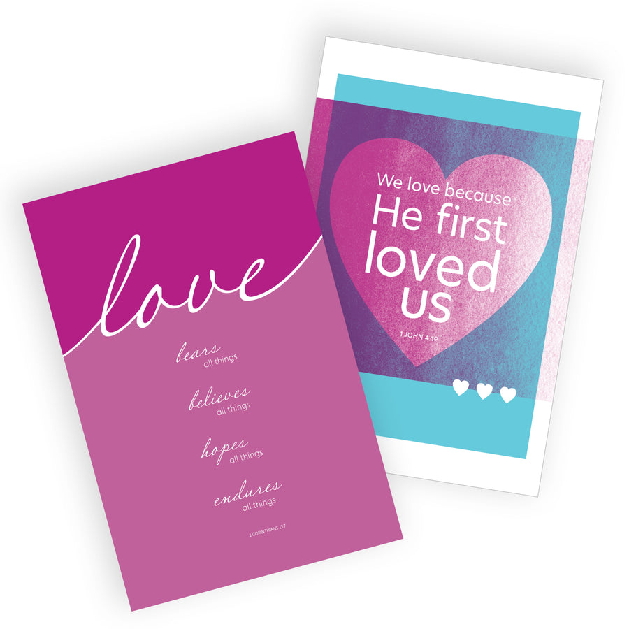 Pair of love themed Bible verse postcards. One is fuchsia with script writing reading Love bears all things, believes all things, hopes all things, endures all things. 1 Corinthians 13:7. The other is a light blue with a similar warm purple color. Inside a heart shape is the words We love because He first loved us. 1 John 4:19.