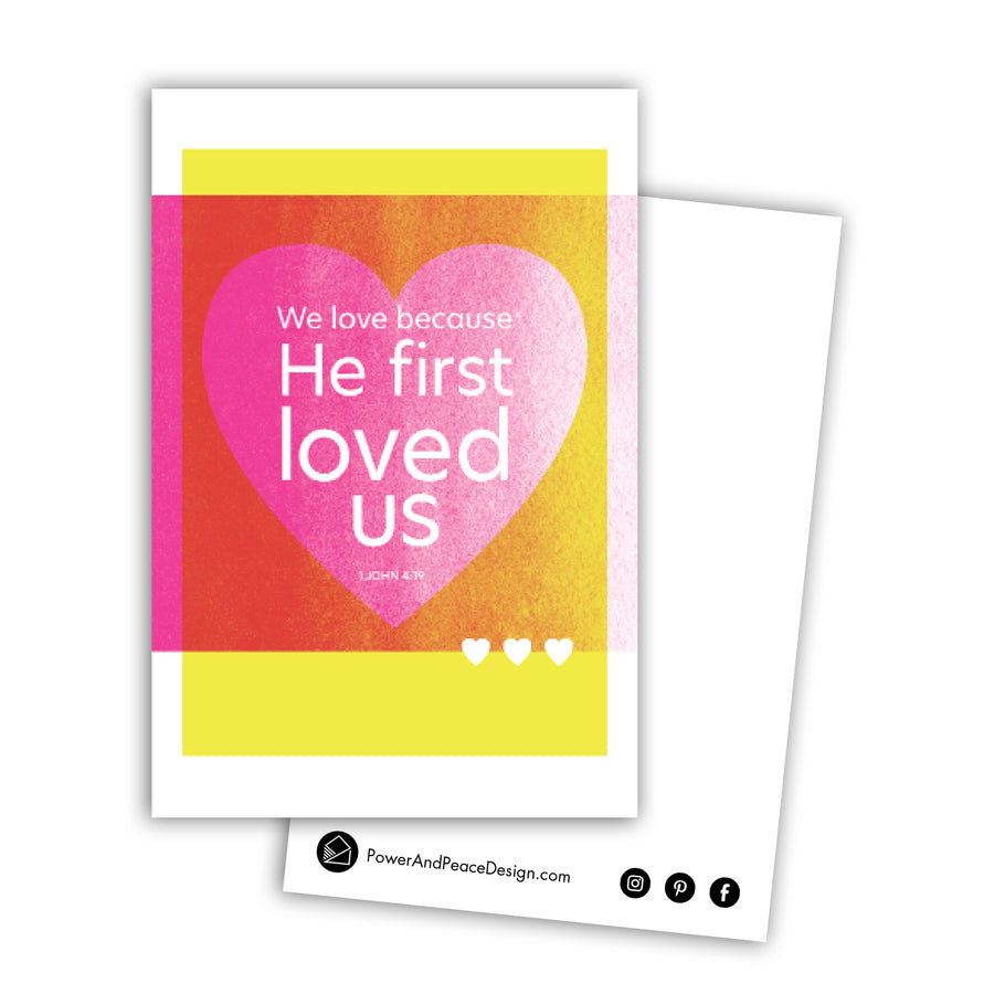 Yellow and magenta Scripture art postcard. Design features a large heart with 1 John 4:19 We love because He first loved us.
