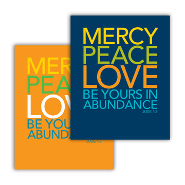 Two overlapping Christian typography art prints in different colors. Both read Mercy, peace, love be yours in abundance. Jude 1:2. The one in the background is orange with yellow, green, white, and teal text. The one in the foreground is navy blue with text in yellow, lime green, orange, and teal.