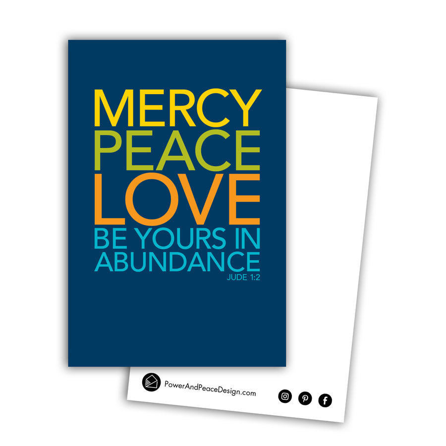 Bible postcard with the words Mercy, peace, love be yours in abundance Jude 1:2. Type is large and bold and all caps on a navy blue background. Words are in yellow, lime green, orange, and teal. Back of the postcard is white with black Power and Peace Design logo and website.