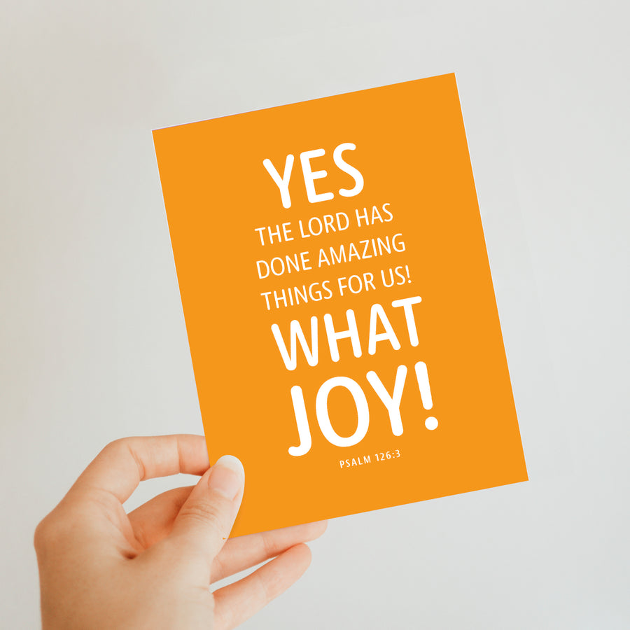 Hand holding Bible verse greeting card with white text from Psalm 126:3. Yes, the Lord has done amazing things for us! What joy! Psalm 126:3.