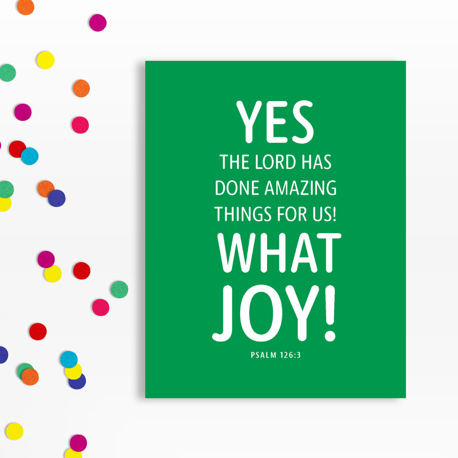 Colorful modern birthday card with Scripture. Card is green with white text reading Yes, the Lord has done amazing things for us! What joy! Psalm 126:3. Card shown near confetti.