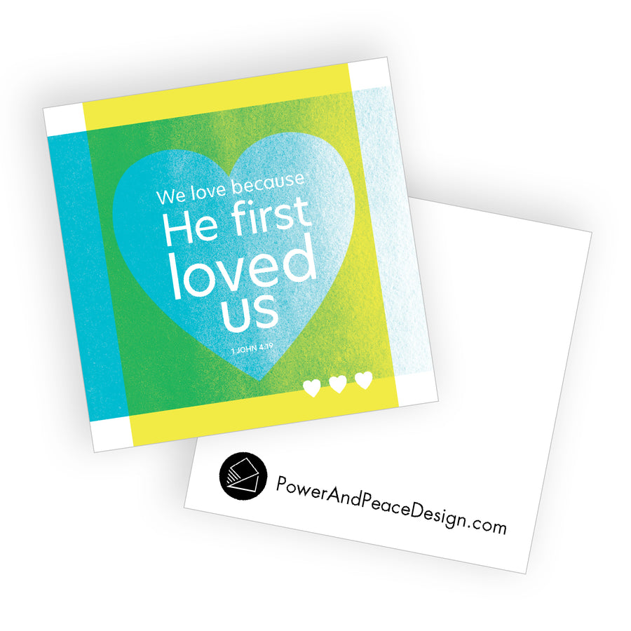 Bright colorful Bible verse mini valentine card with We love because He first loved us. 1 John 4:19.